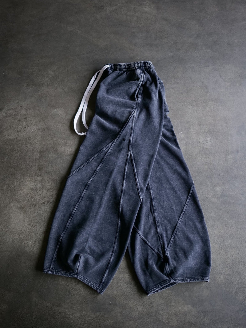 Goji Longevity black washed sweatpants — side view showing wide-fit silhouette